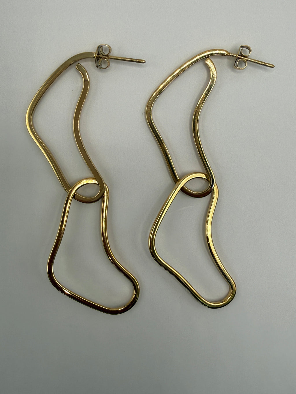 gold Forma 21 earrings on a light gray background